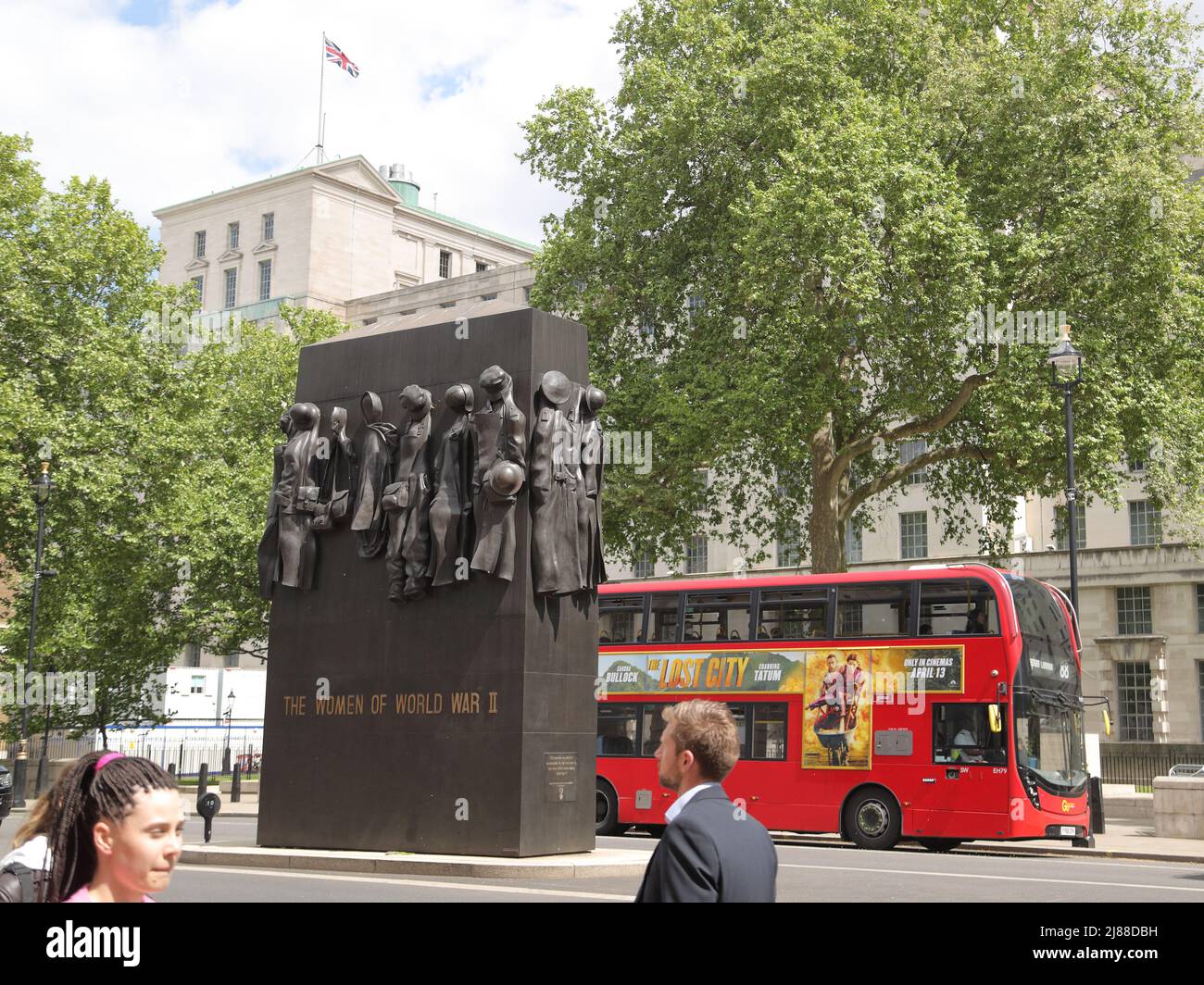 Ein roter Londoner Doppeldeckerbus fährt am Denkmal für die „Frauen im Zweiten Weltkrieg“ in Whitehall, London, Großbritannien, vorbei Stockfoto