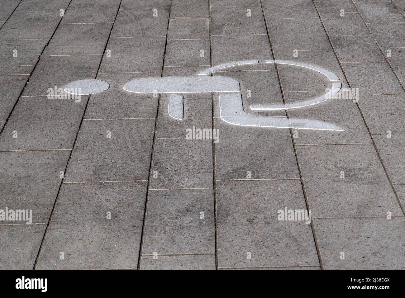 Piktogramm eines Rollstuhls auf der Straße, markiert einen Parkplatz für einen Rollstuhlfahrer Stockfoto