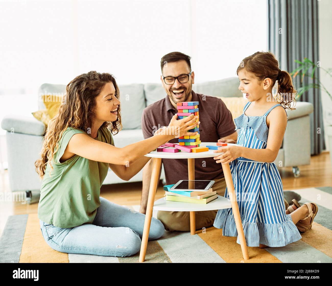 Kind Tochter Familie glücklich Mutter Vater Brettspiel schmackhaft spielen Spaß zusammen Mädchen fröhlich zu Hause Stockfoto