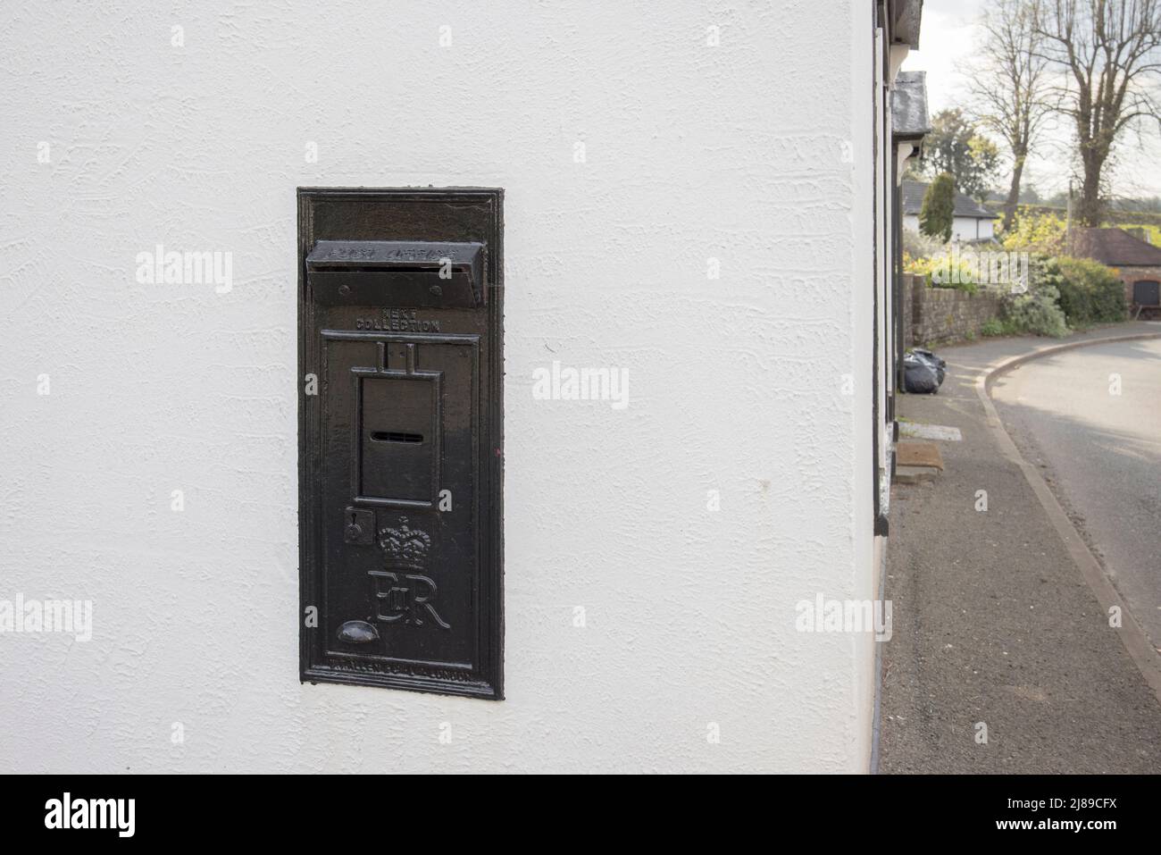 Royal Mail Briefkasten in Wand eines Privathauses gesetzt, schwarz lackiert und blockiert, um Gebrauch zu verhindern, Govilon, Wales, Großbritannien Stockfoto