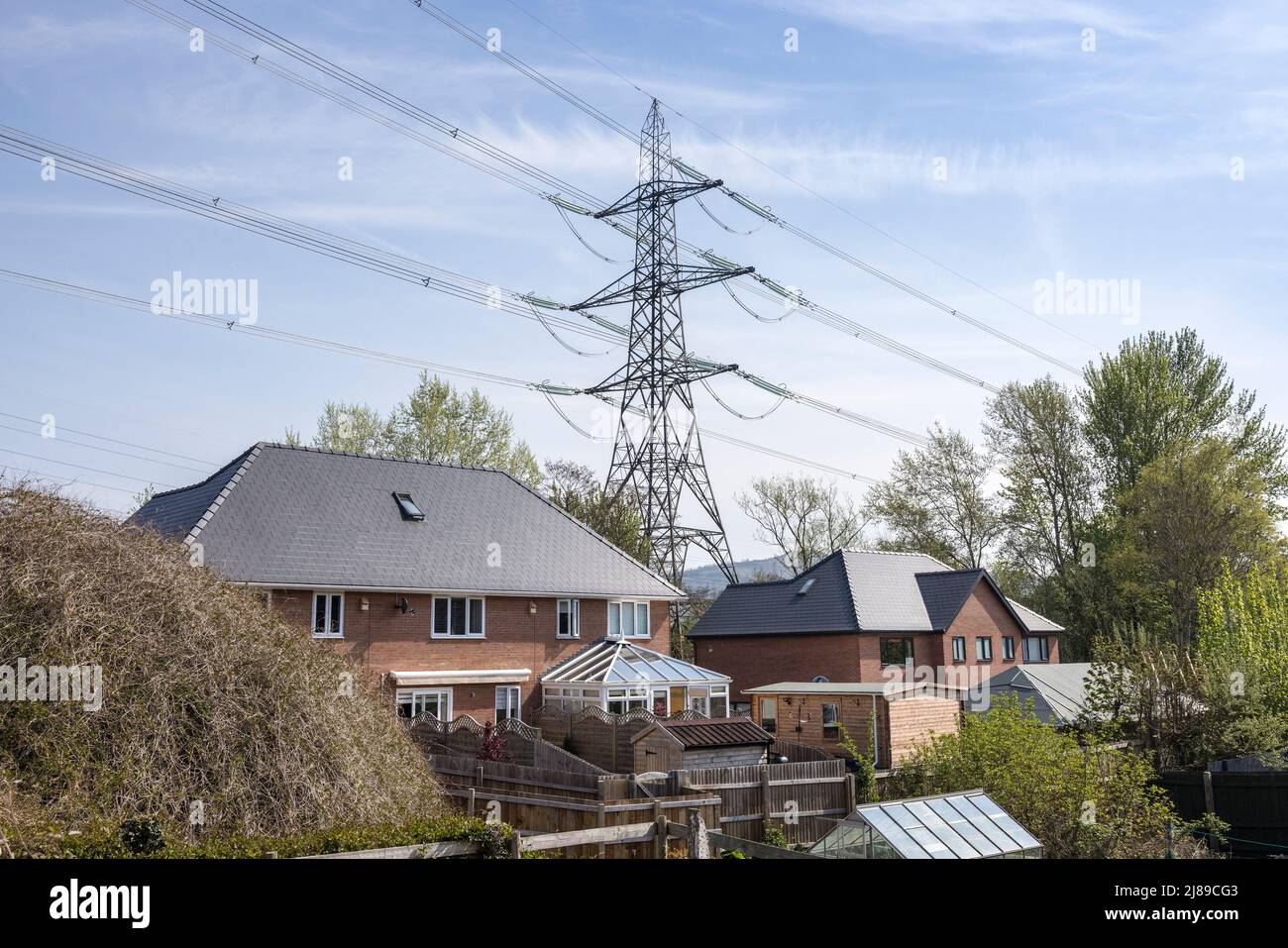 Von Strommasten überschattete Häuser, Llanfoist, Wales, Großbritannien Stockfoto