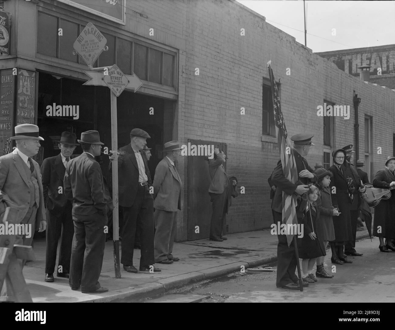 Salvation Army, San Francisco, Kalifornien. Männer kommen aus der benachbarten Bar, um zuzusehen, und kehren zur Bar zurück. (San Francisco soll pro Kopf mehr Whiskey trinken als jede andere Stadt in den Vereinigten Staaten). [Schilder: „No Parking - One Way Street“]. Stockfoto