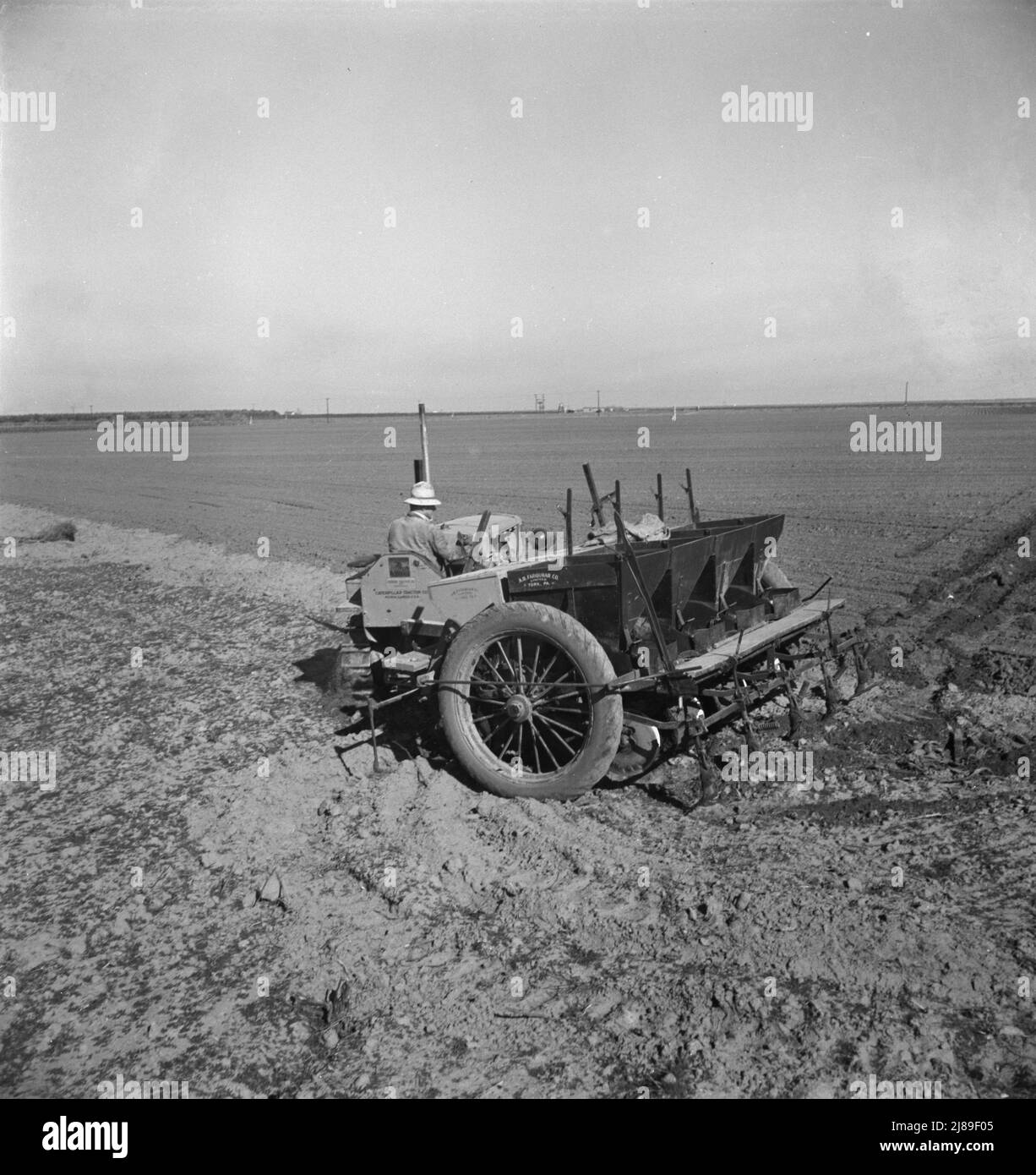 Kern County, Kalifornien. Großräumige mechanisierte Landwirtschaft. Der Kartoffelpflanzer, der von einer Besatzung von drei Männern betrieben wird, macht die Reihen, düngt und pflanzt in einem Arbeitsgang. Stockfoto