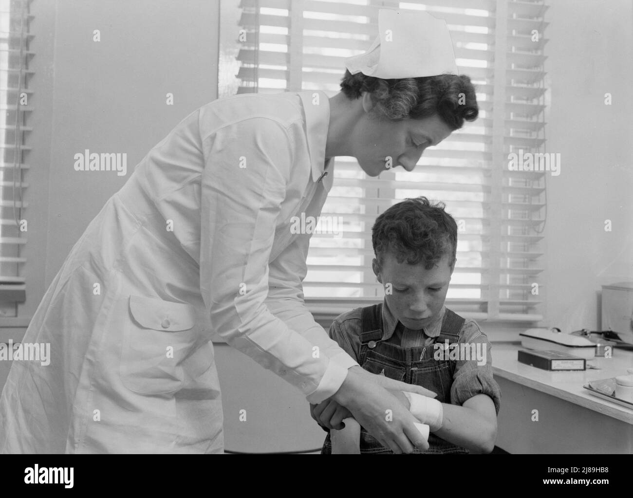 Camp der Farm Security Administration (FSA) in Farmersville, Tulare County für wandernde Landarbeiter. Wandernde Jungen kommen in die Klinik, um die Krankenschwester der Landwirtschafts- und Ärztevereinigung (FSA) zu besuchen. Stockfoto