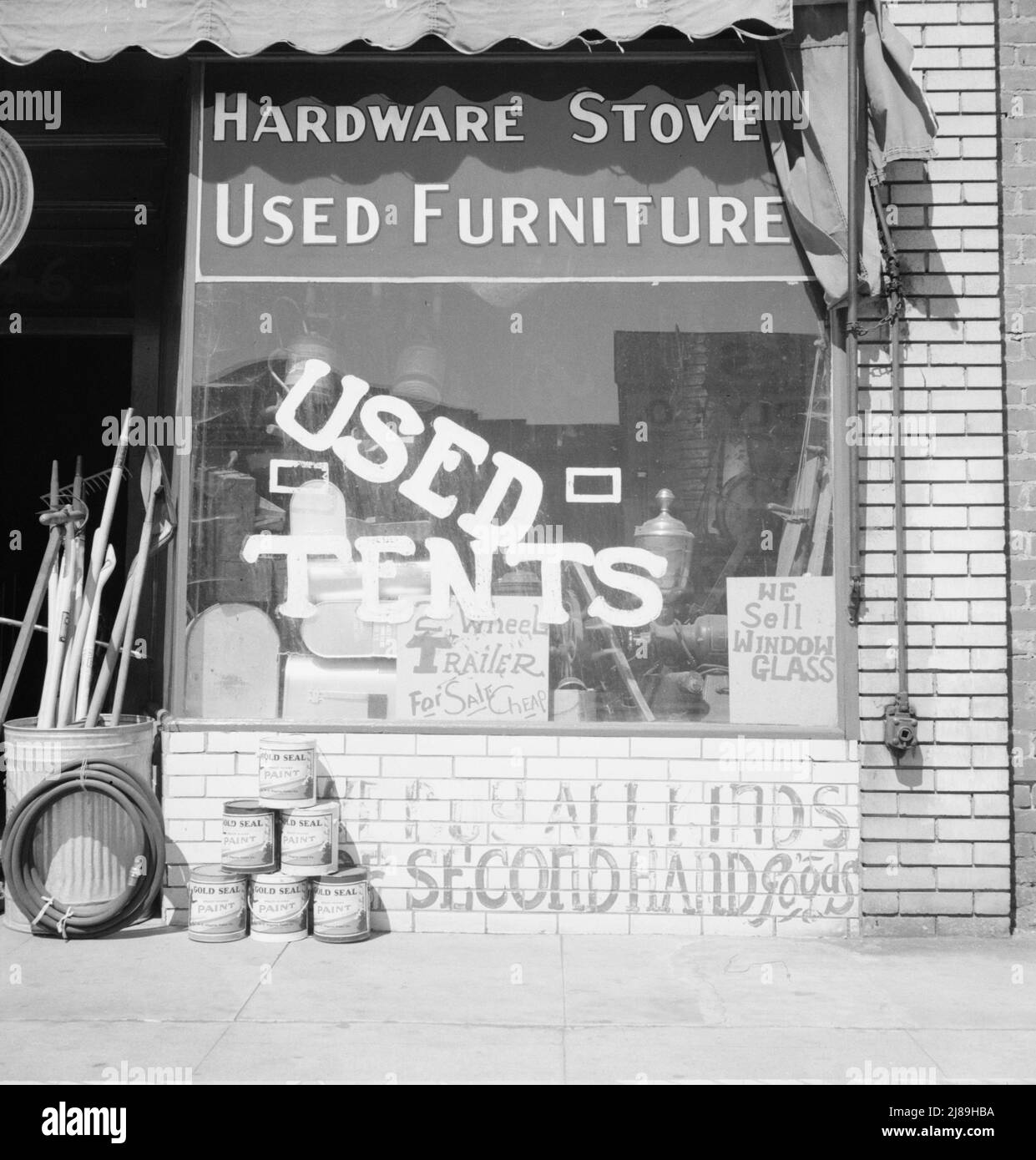 Fresno. Auf US 99. StoreFront der Stadt San Joaquin Valley. Kalifornien. [Geschäft mit gebrauchten Hardware, Öfen, gebrauchten Möbeln, gebrauchten Zelten, Anhängern, Fensterglas, Goldsiegelfarbe]. Stockfoto