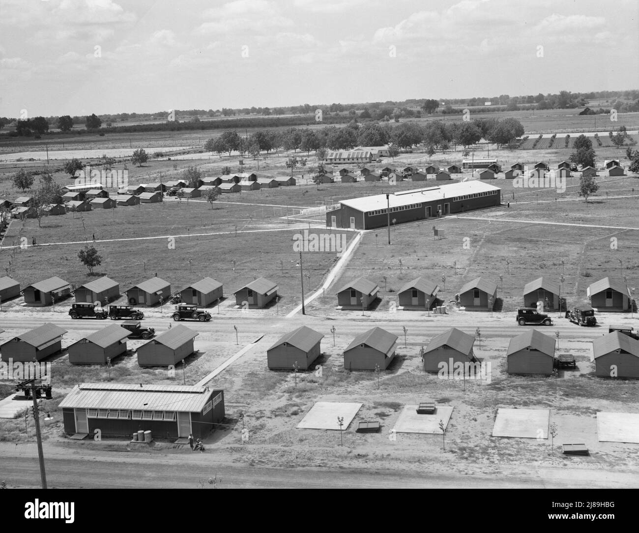 Tulare County. Ansicht des Lagers der Farm Security Administration (FSA) für Wanderarbeiter. Farmersville. Vom Wasserturm aus gesehen, zeigt er vorgefertigte Stahlunterstände für Landarbeiter. Das Gebäude unten links enthält eine Toilette. Großes Gebäude im Zentrum ist Camp Wäscherei. Dieses Camp befindet sich in einem Gebiet aus Baumwolle, Trauben und Zitrusfrüchten. Kalifornien. Stockfoto