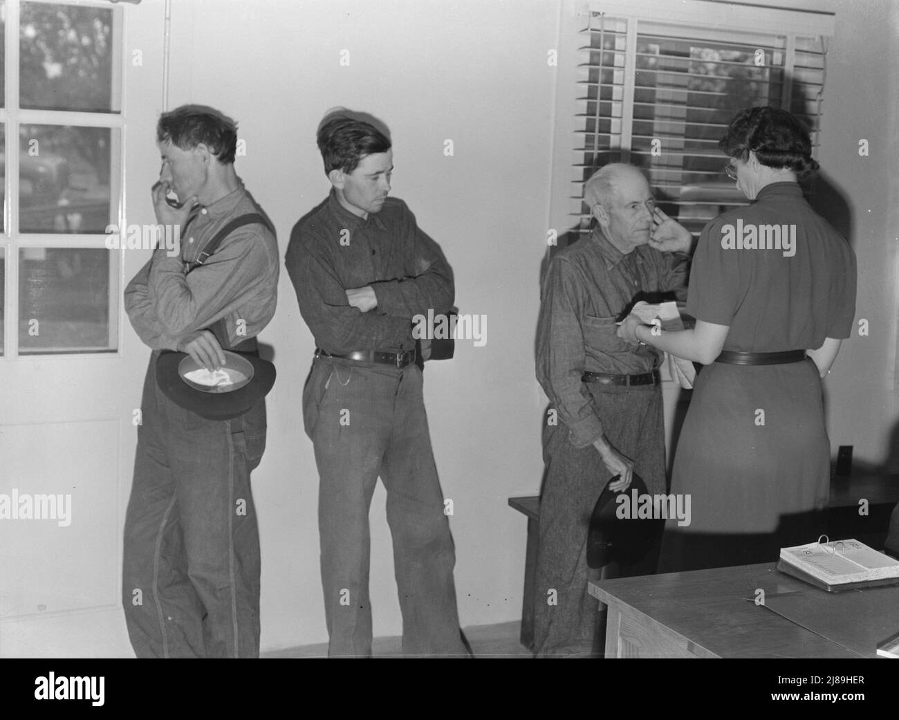 Tulare County, Kalifornien. Camp für wandernde Landarbeiter in Farmersville. Söhne, Wanderarbeiter, bringen kranken und alten Vater in die Lagerklinik. Stockfoto