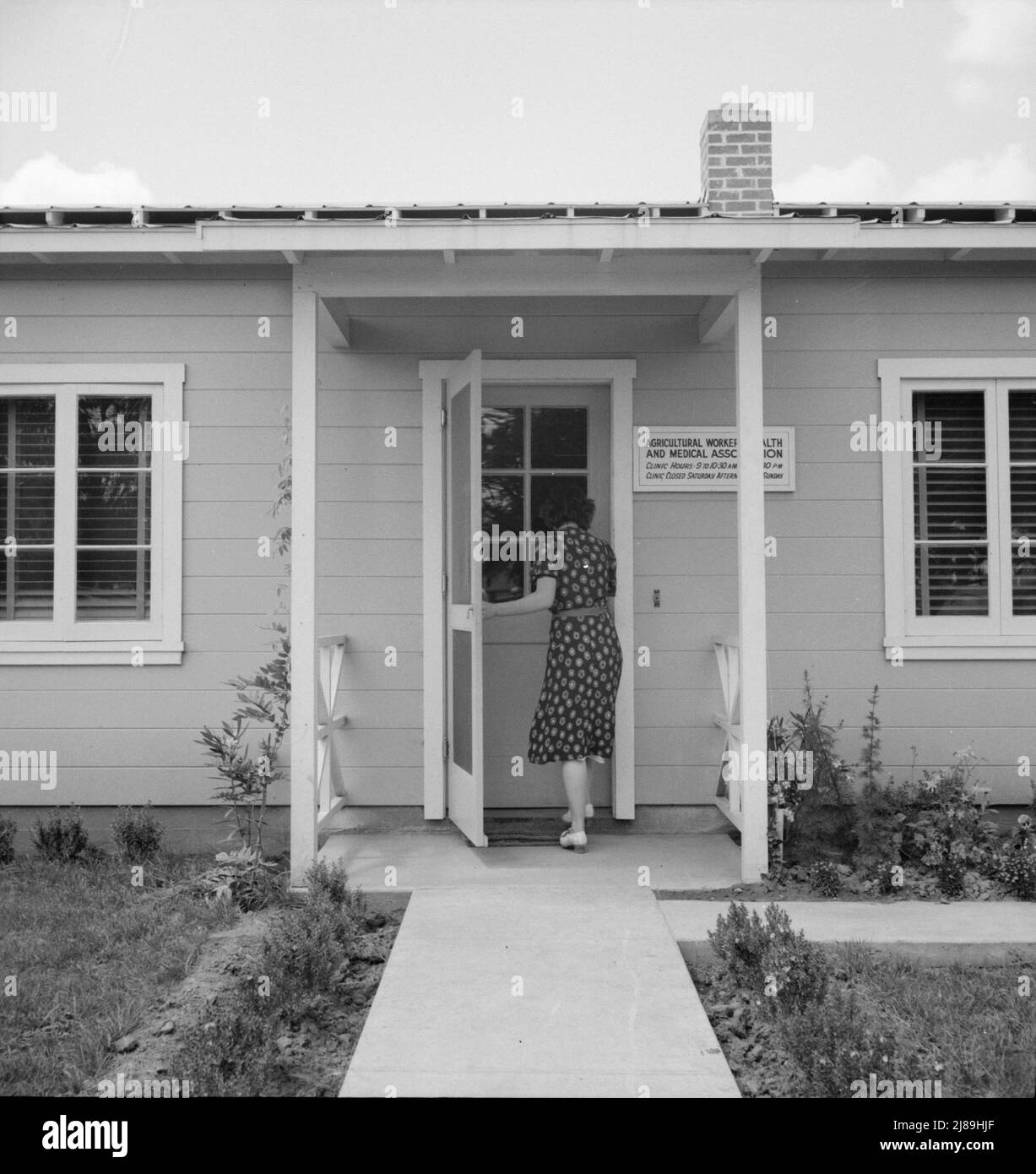 Tulare County, Farmersville, Kalifornien. Camp der Farm Security Administration (FSA) für wandernde Landarbeiter. Eintritt in die Klinik der Agricultural Workers' Health and Medical Association (FSA) für die Hilfe der Krankenschwester bei kranken Babys. Eine ältere Frau sagt: „Ich bin nur eine Nachbarin und habe wirklich Mitleid mit ihnen“. Stockfoto