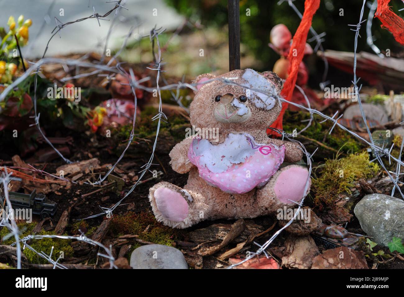 Ein blutiges Kinderspielzeug, das im Kunstprojekt „Screams of Souls“, das in Lemberg präsentiert wurde, zu sehen war. Große Karte der Ukraine mit blutigem Kinderspielzeug, zerstörten Häusern, Stacheldraht und Ähren von Weizen, die durch die verbrannte Erde sprießen. Die Autorin des Projekts ist Ulyana Datsishin. Russland marschierte am 24. Februar 2022 in die Ukraine ein und löste damit den größten militärischen Angriff in Europa seit dem Zweiten Weltkrieg aus Stockfoto