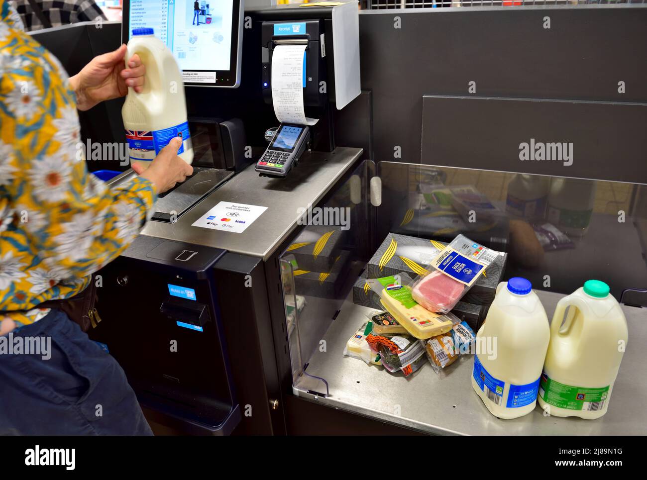 Frau, die beim Selbstbedienungskassen einkaufen geht, bis sie im Aldi Supermarkt, Großbritannien, ist Stockfoto