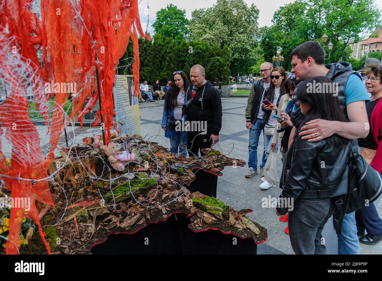 Lviv, Ukraine. 14.. Mai 2022. Die Menschen sahen sich das Kunstprojekt ''Screams of Souls'' an, das in Lemberg vorgestellt wurde. Große Karte der Ukraine mit blutigem Kinderspielzeug, zerstörten Häusern, Stacheldraht und Ähren von Weizen, die durch die verbrannte Erde sprießen. Die Autorin des Projekts ist Ulyana Datsishin. Russland marschierte am 24. Februar 2022 in die Ukraine ein und löste damit den größten militärischen Angriff in Europa seit dem Zweiten Weltkrieg aus (Bild: © Mykola Tys/SOPA Images via ZUMA Press Wire) Stockfoto