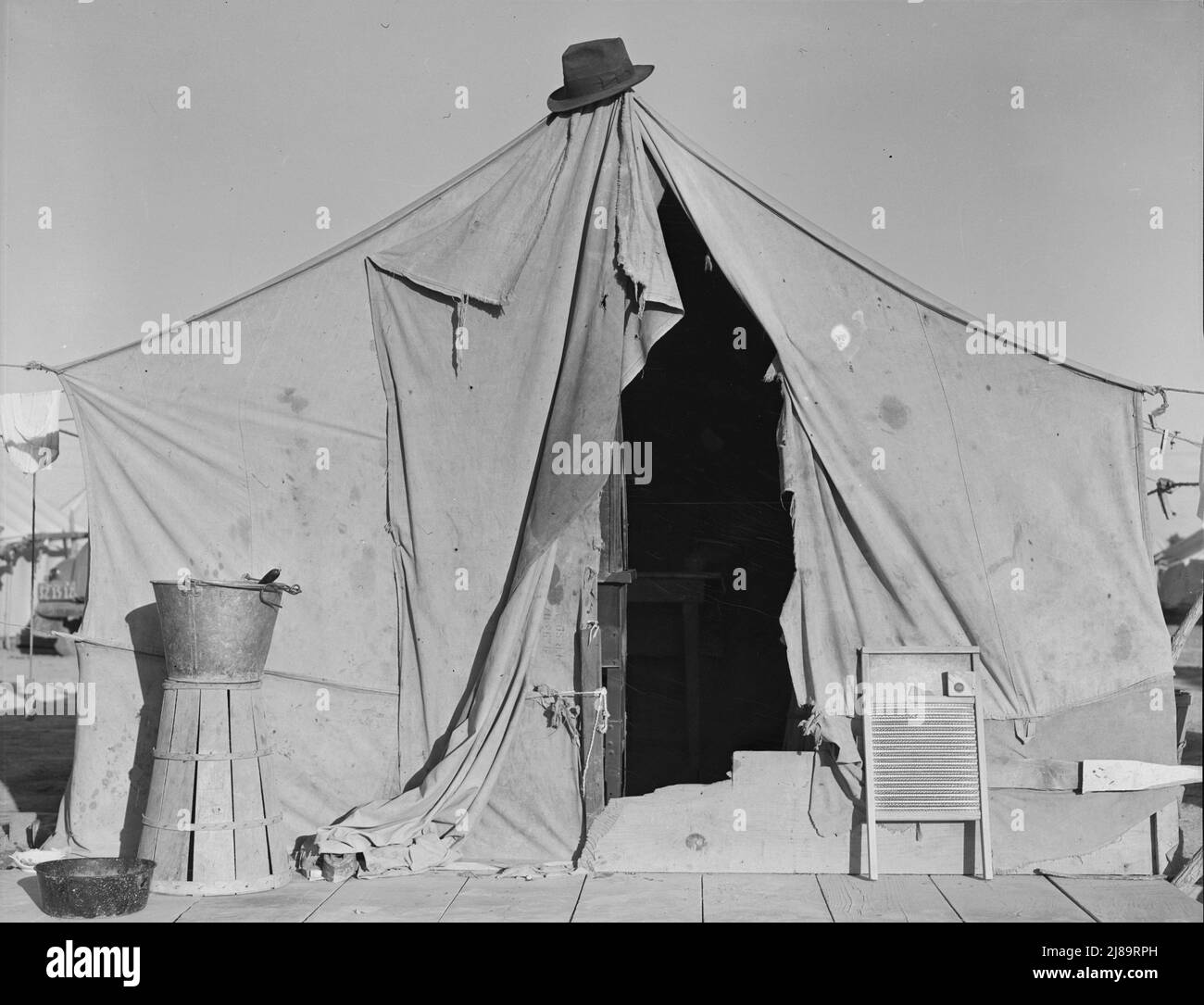 Eines von einer Reihe von Zelten, Heimat eines Erbsensammler. In Der Nähe Von Calipatria, Imperial Valley, Kalifornien. [Aufgedrehten Korb zum Tragen von Erbsen und Waschbrett beachten] Stockfoto