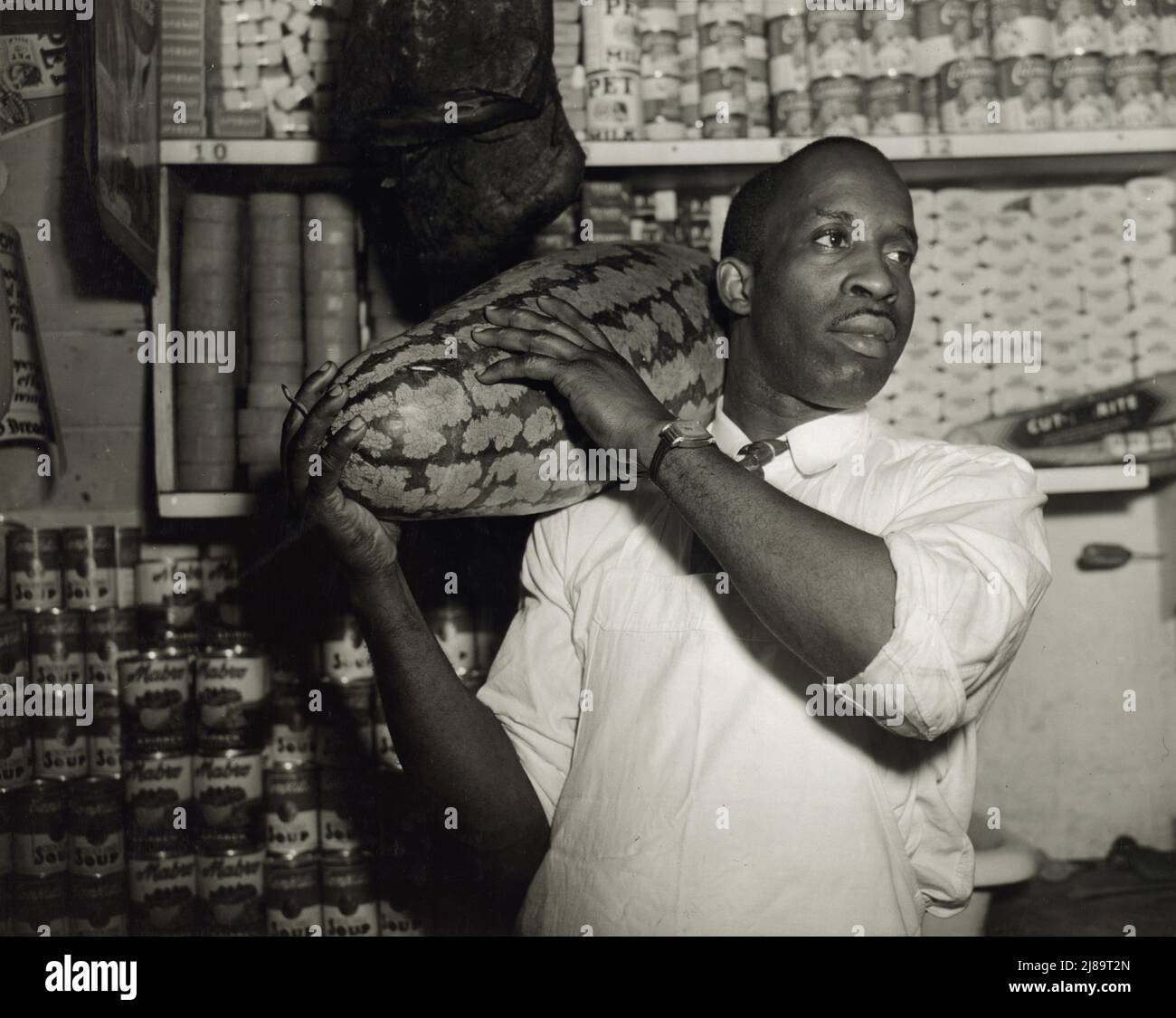 Washington, D.C. Herr J. Benjamin, Eigentümer des Lebensmittelladens, der von Frau Ella Watson, einer Regierungsfigur, bevormundet wurde. Stockfoto