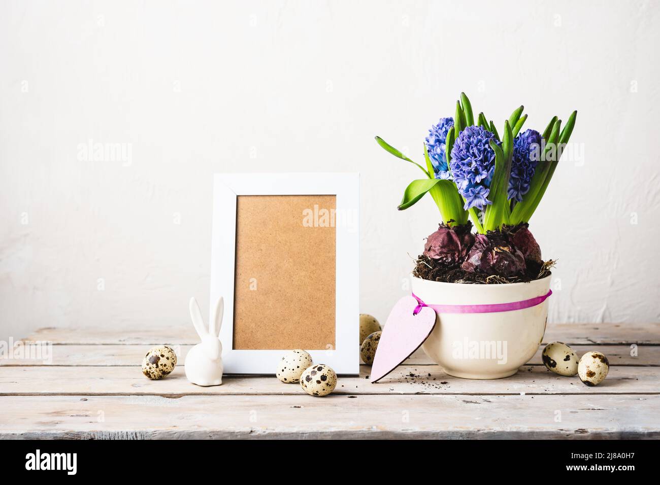 Blaue Hyazinthen, Fotorahmen und Wachteleier auf einem Holztisch. Stockfoto