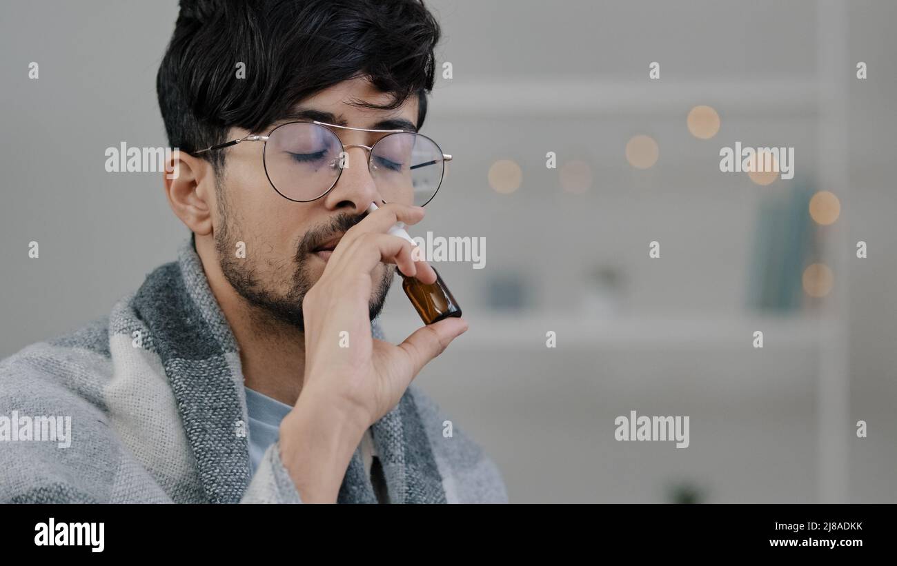 Porträt kranker arabischer hispanischer bärtiger kranker Mann, der an saisonaler Allergie leidet Atemwegsvirus-Symptome schlechtes Gefühl laufende Nase wendet Nasenspray an Stockfoto