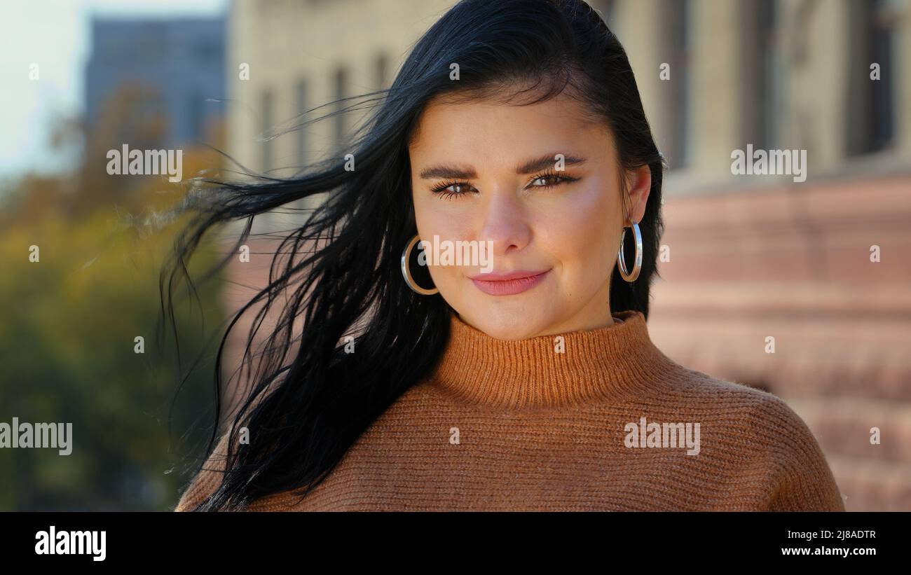 Junge attraktive hispanische Mädchen Student Modell Blick auf Kamera posiert allein im Freien stehend für Nahaufnahme Porträt professionell schön lächelnd Stockfoto