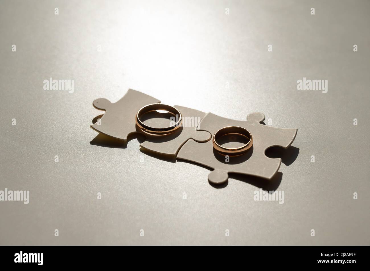 Eheringe und Puzzleteile. Ehemann und Ehefrau ergänzen sich perfekt. Stockfoto