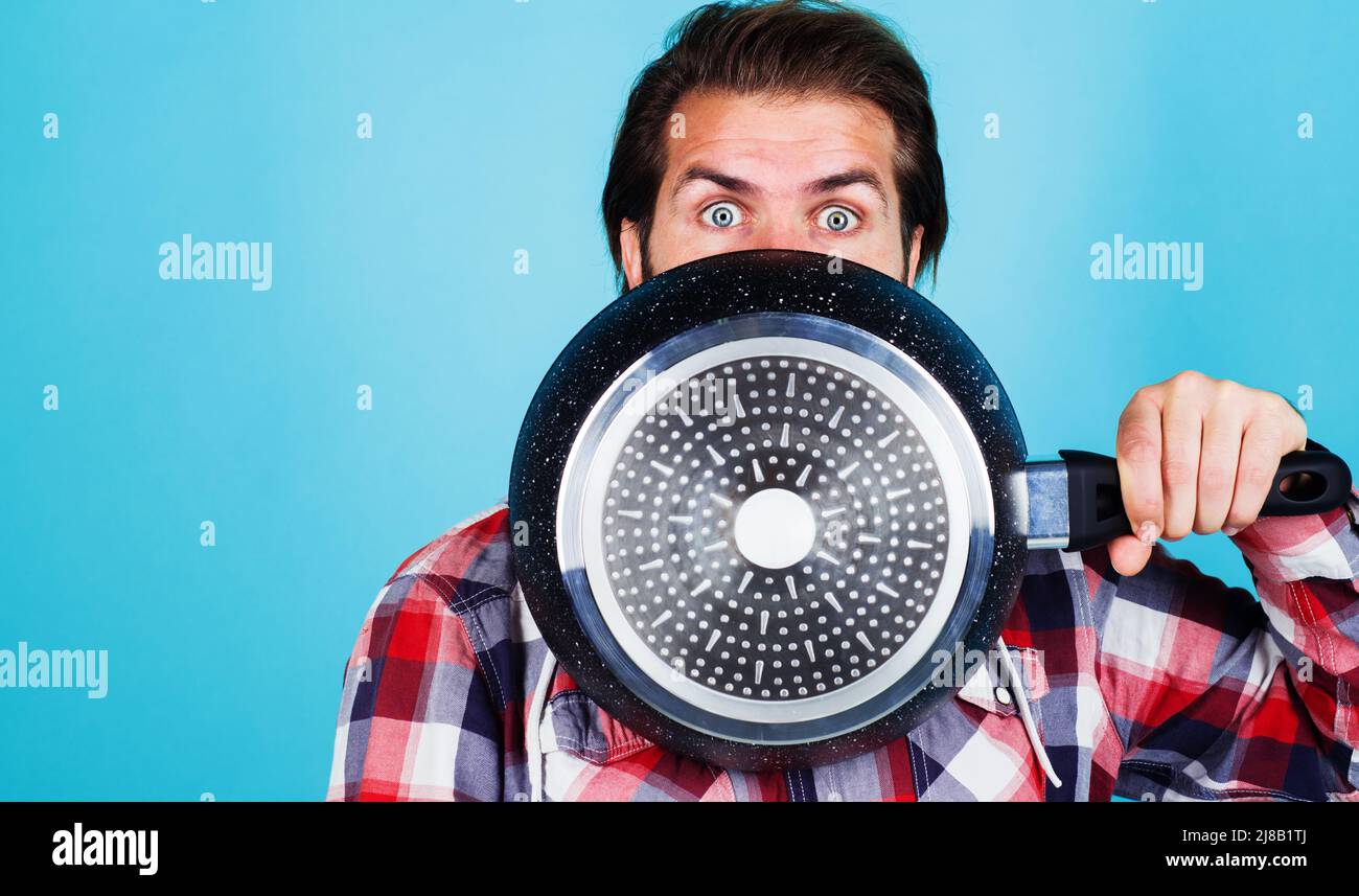 Männlicher Koch mit Frypan. Küchenutensilien. Kochwerkzeuge. Kochgeschirr in der Küche. Bratpfanne. Zubereitung von Speisen. Stockfoto