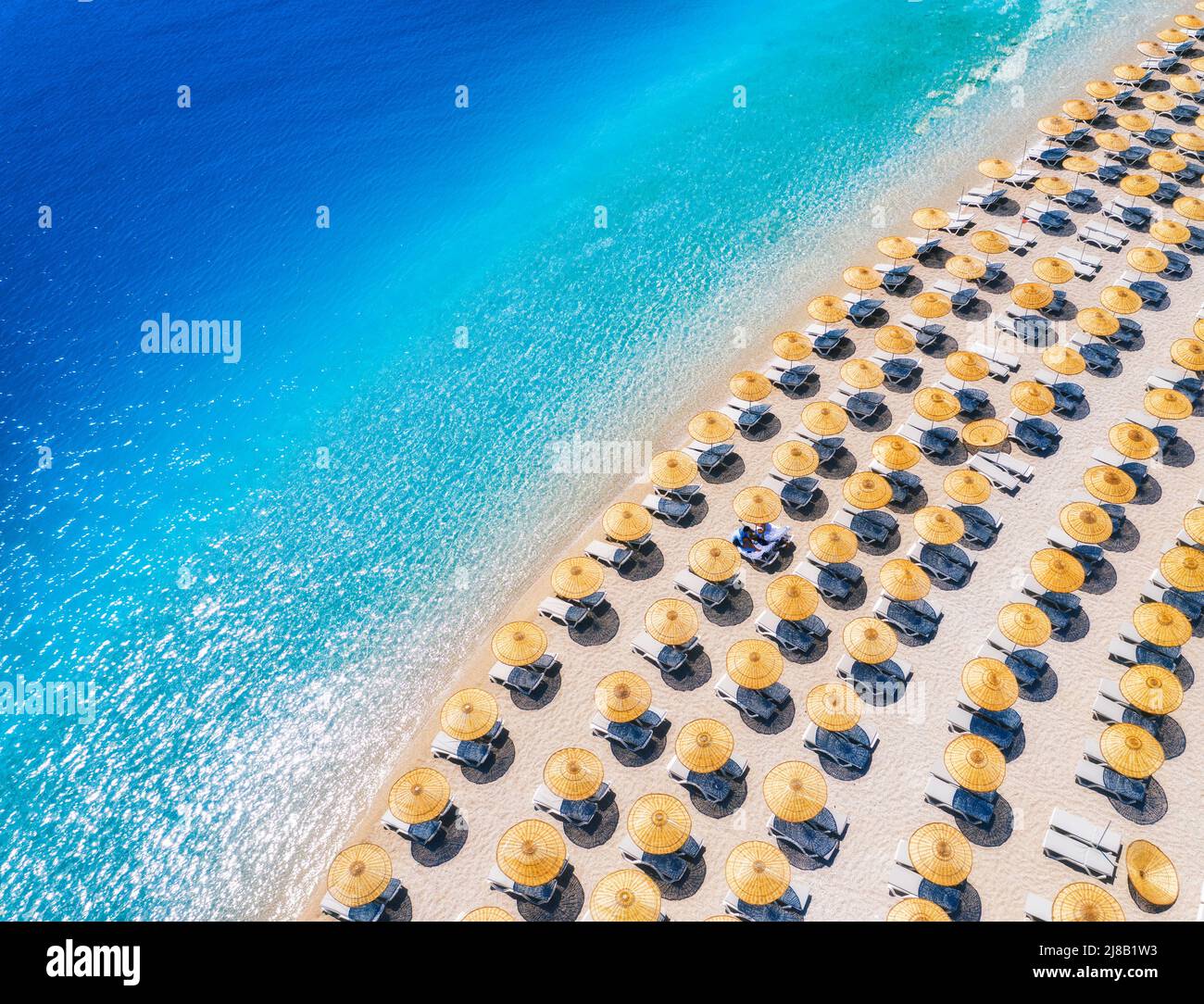 Luftaufnahme des Meeres, leerer Sandstrand mit Sonnenliegen und Sonnenschirmen Stockfoto