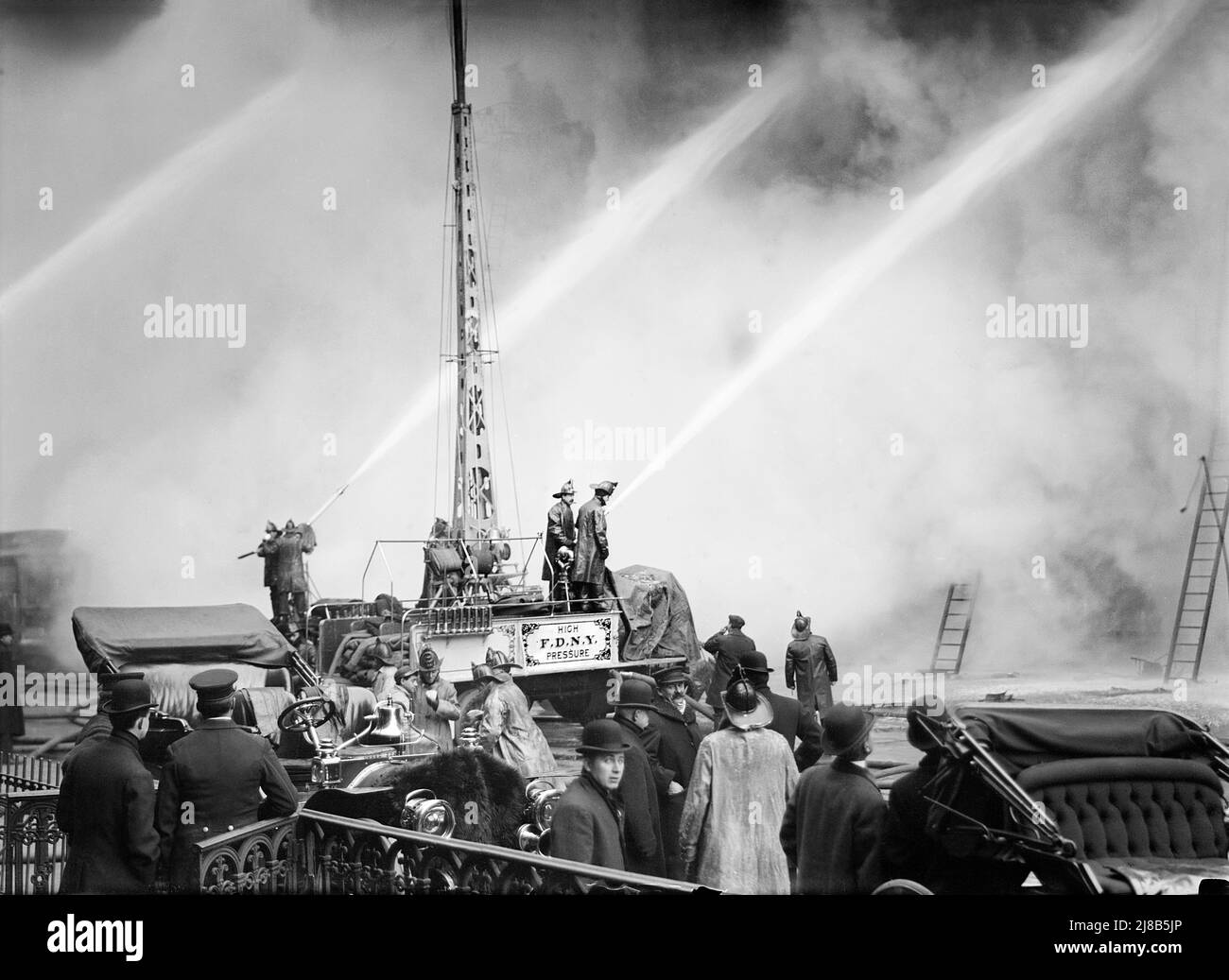 Feuerwehrmann spritzt Wasser auf brennendes Gebäude, 14. Street, New York City, New York, USA, Bain News Service, Dezember 1909 Stockfoto