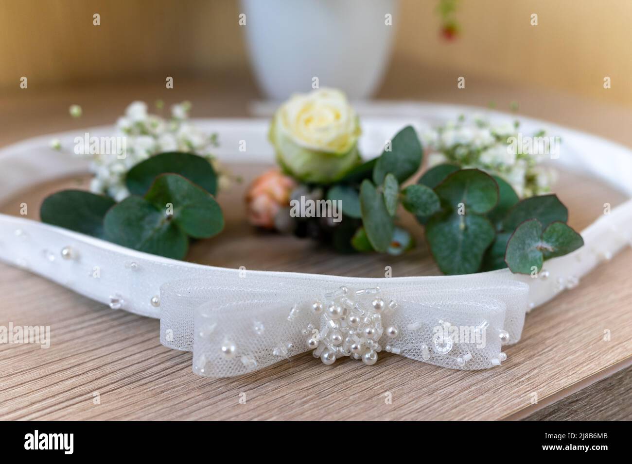 Braut Gürtel und Hochzeitsboutonniere liegen auf dem Tisch Stockfoto