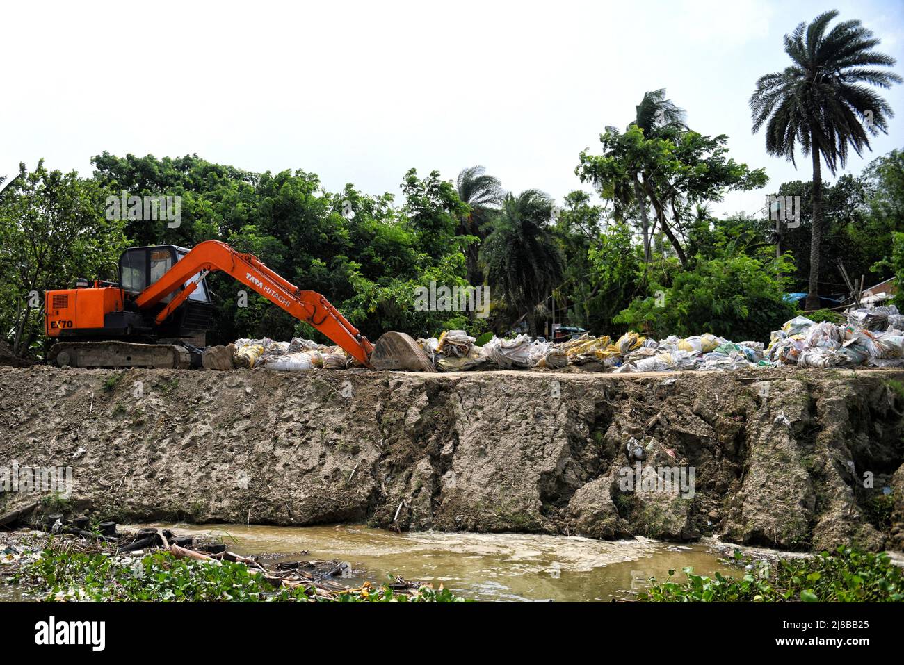 Hooghly, Indien. 14.. Mai 2022. Eine JCB-Maschine (Joseph Cyril Bamford) wurde aufgrund von Bodenerosion am Ufer des Ganges eingesetzt. Extreme Bodenerosion am Ufer des Ganges in der Nähe von Hooghly, etwa 100km weit von der Stadt Kalkutta entfernt. Das Flussufer von Hooghly ist aufgrund seiner Topographie und geografischen Lage sehr anfällig für Klima- und wetterbedingte Gefahren. Kredit: SOPA Images Limited/Alamy Live Nachrichten Stockfoto