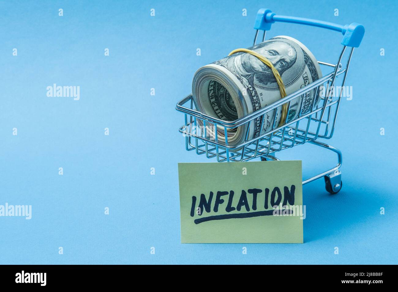 Dollar sind in einem Lebensmittelkorb, mit einem Plakat, auf dem die Inschrift Inflation. Stockfoto