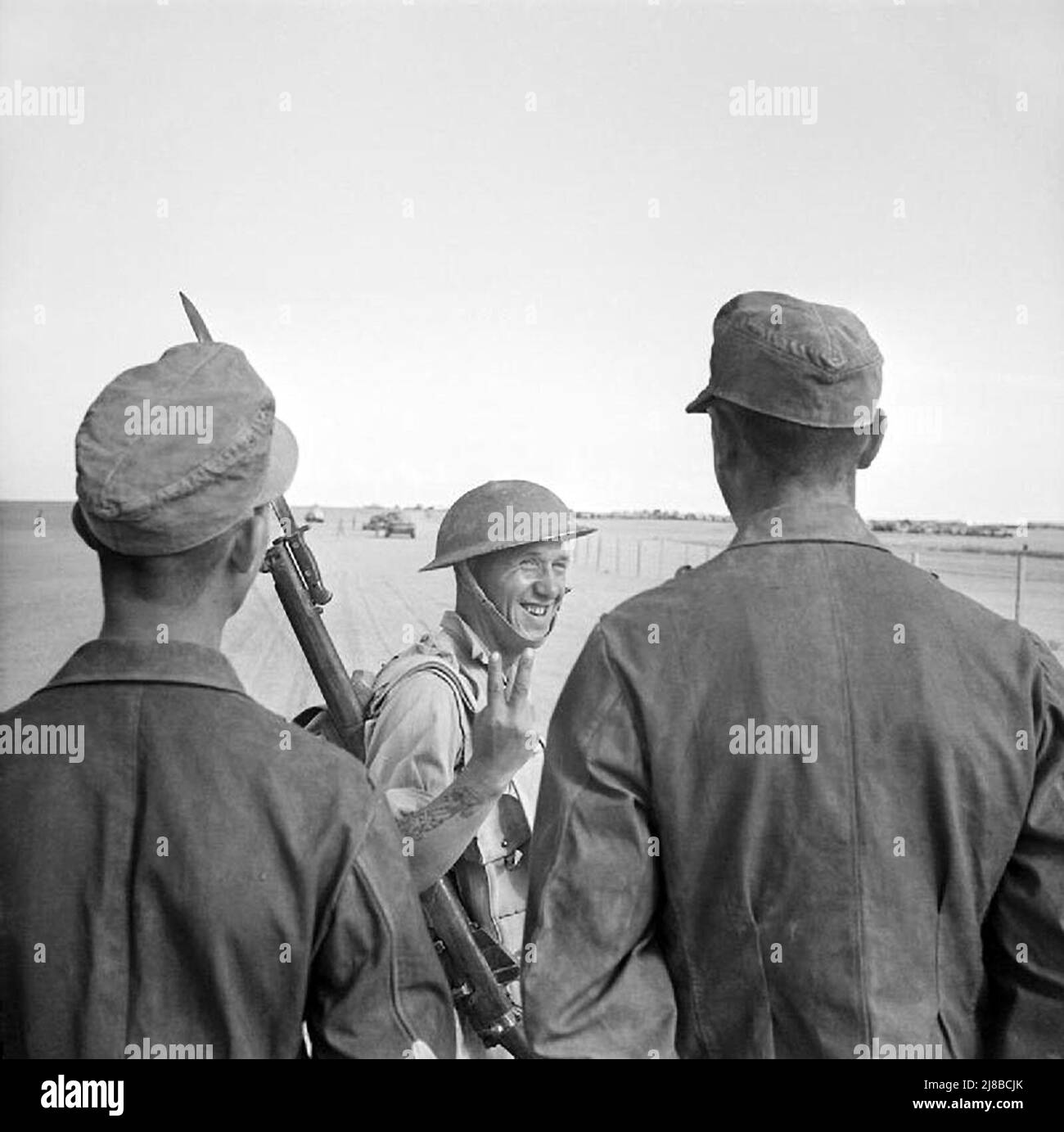 Der britische Soldat gibt deutschen Gefangenen während der zweiten Schlacht von El Alamein während des Nordafrikafeldzugs WW2 eine V-Geste Stockfoto