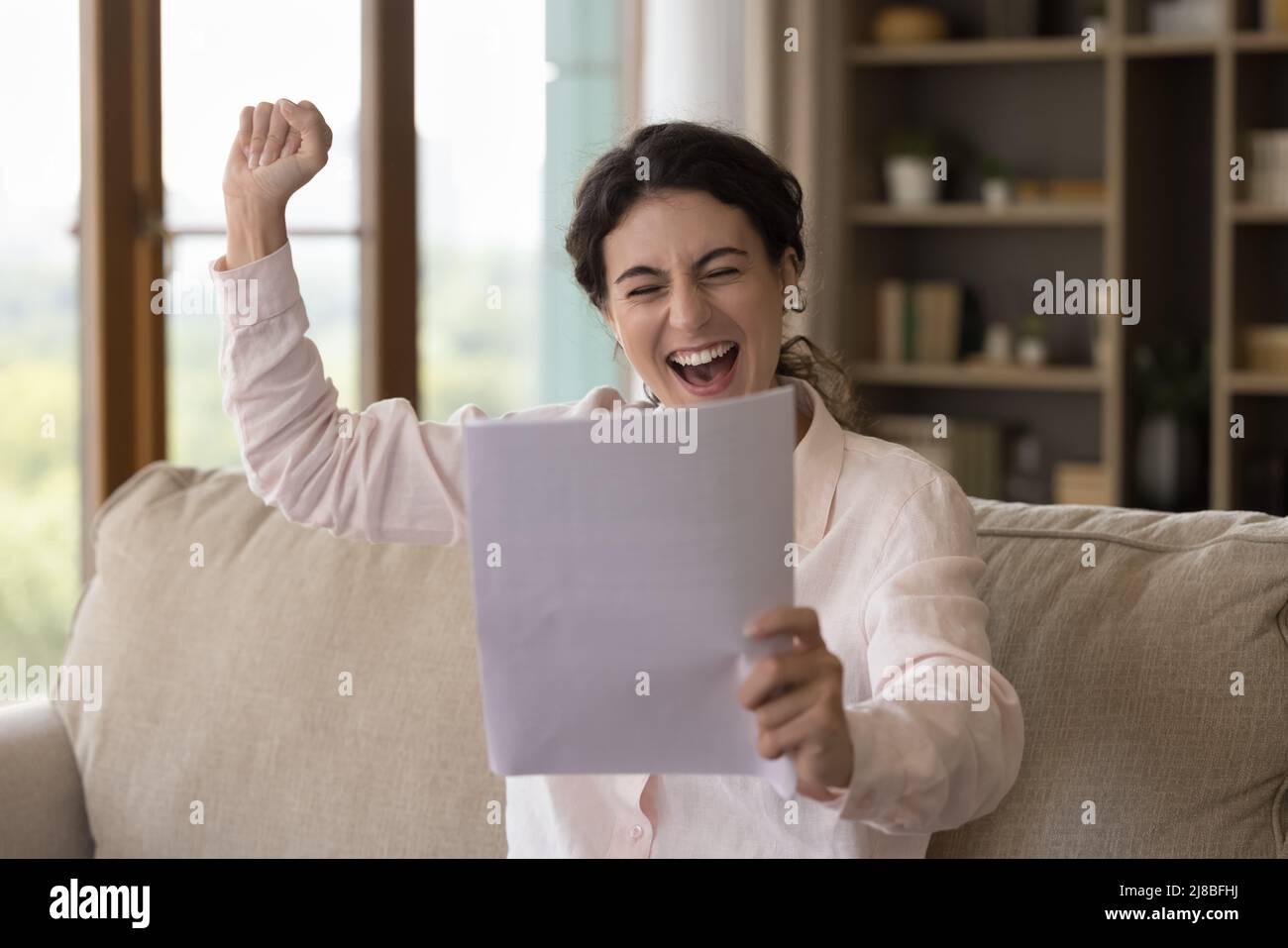 Junge aufgeregt Frau lesen Papier Benachrichtigung fühlt sich überglücklich Stockfoto