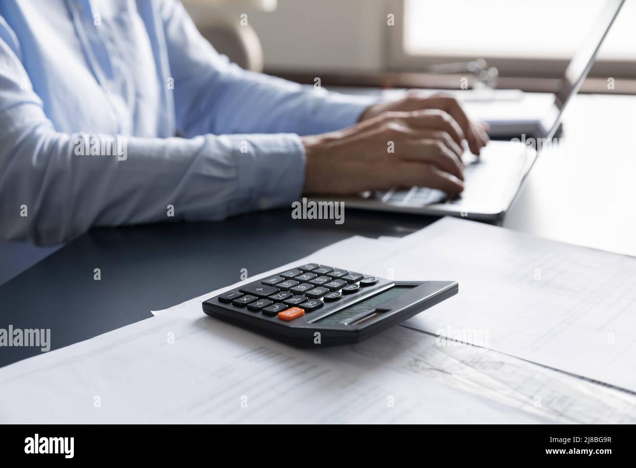 Weiblicher beruflicher Arbeitsplatz mit Rechner, Finanzunterlagen Stockfoto