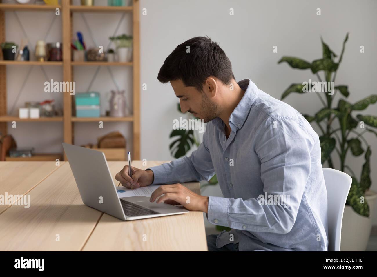 Fokussierter junger Geschäftsmann mit Laptop-Computer Stockfoto