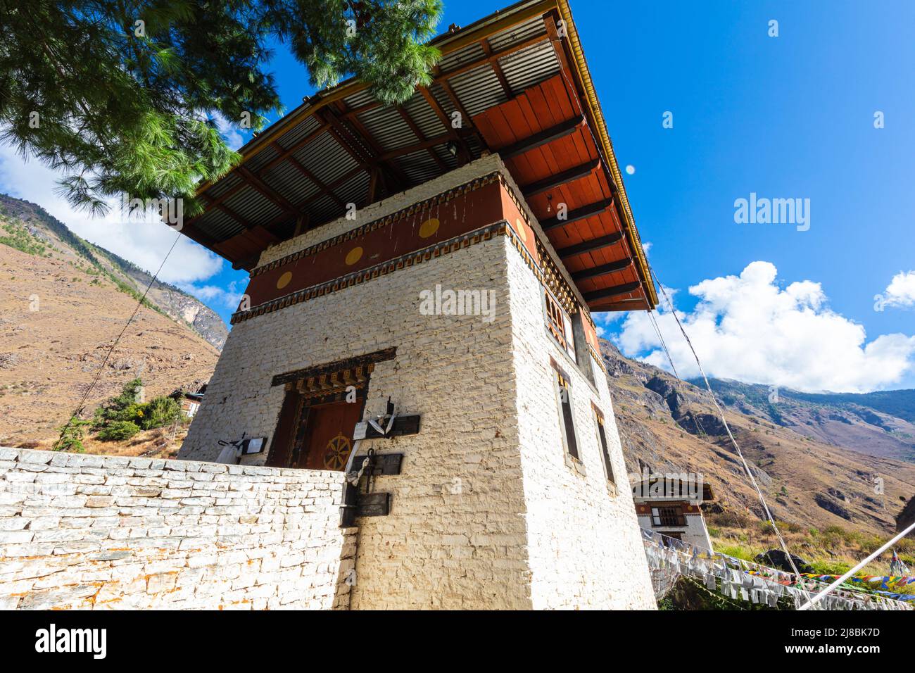 Brückenhaus einer Hängebrücke über den schnell fließenden Gebirgsfluss im Himalaya von Bhutan. Traditionelle bhutanische Architektur. Weiß getüncht w Stockfoto