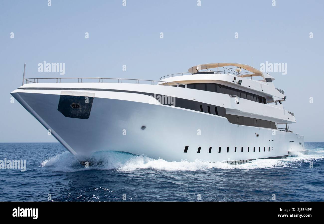 Eine große private Luxusmotoryacht, die auf tropischem Meer mit Bugwelle segelt Stockfoto
