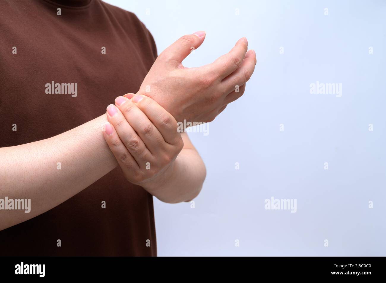 Ein Mann wickelte sich wegen Schmerzen am Handgelenk um sein Handgelenk. Ursachen für rheumatoide Arthritis, Karpaltunnelsyndrom, Gicht. Gesundheitsfürsorge und medizinisches Konzept. Stockfoto