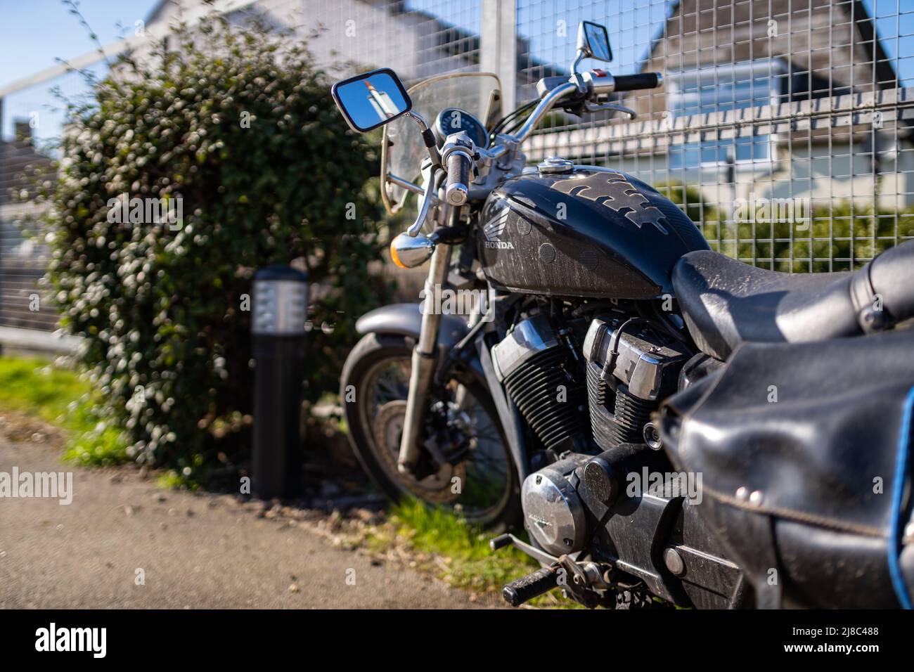 Woodbridge Suffolk UK März 18 2022: Ein Motorrad der Honda VT 750 SA aus dem Jahr 2011, das bei strahlendem Frühlingssonne vor einem klaren blauen Himmel auf einem Pfad sitzt Stockfoto