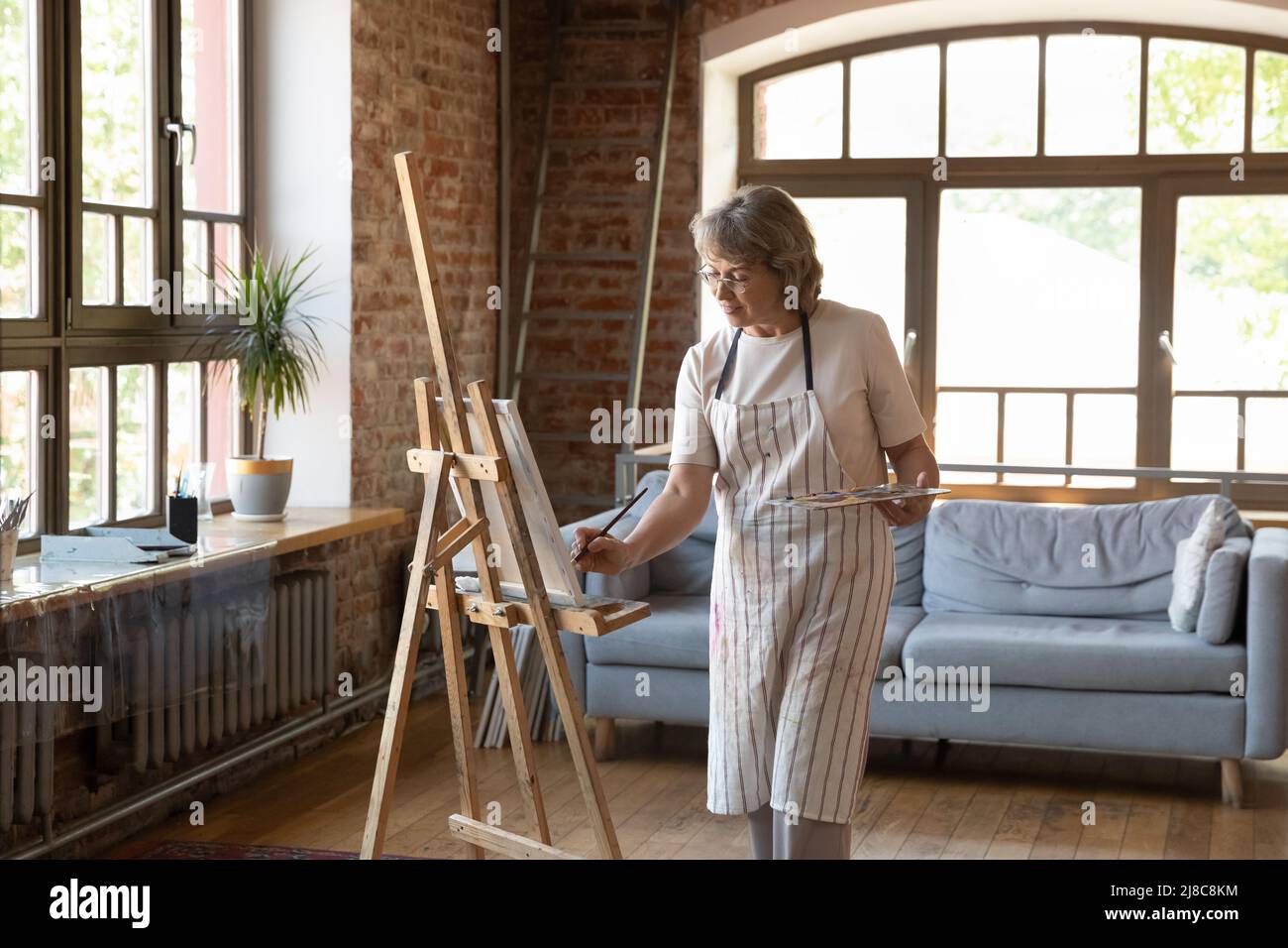 Junge afrikanische Künstlerin, die ein Bild auf Leinwand zeichnet Stockfoto
