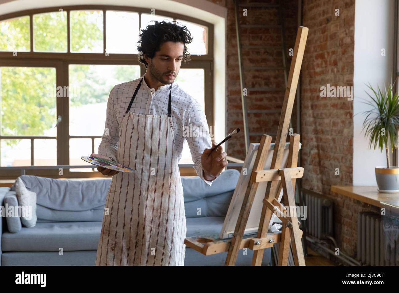 Mann Maler Zeichnung auf Leinwand in der Werkstatt Stockfoto