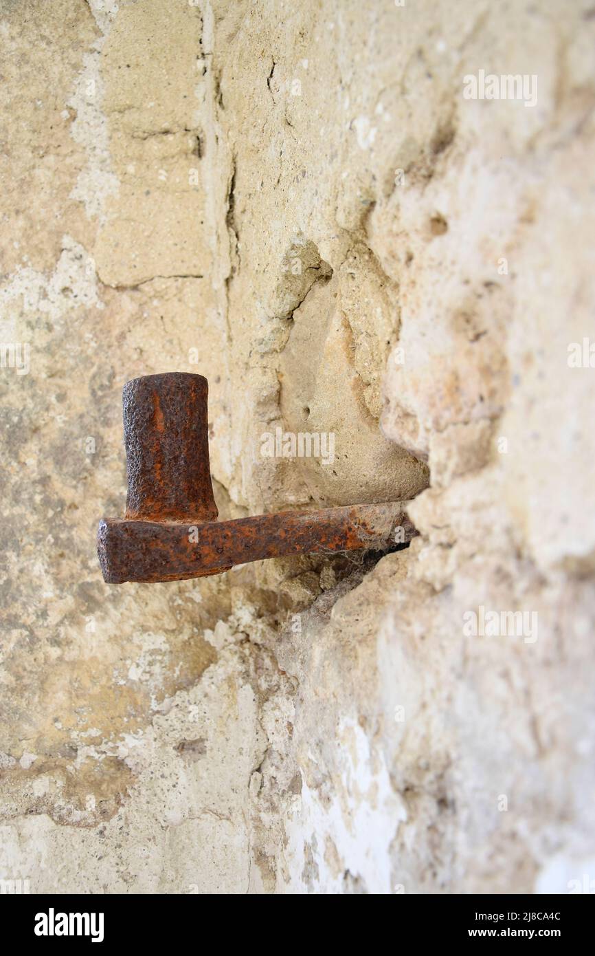 Große antike Schleife in Steinwand eingebettet. Altes Metall mit Rost bedeckt. Die Ruinen einer alten Synagoge. Die Textur des alten verfallenen Mauerwerks. Stockfoto Große antike Schleife in Steinwand eingebettet. Altes Metall mit Rost bedeckt. Die Ruinen einer alten Synagoge. Die Textur des alten verfallenen Mauerwerks. Stockfoto