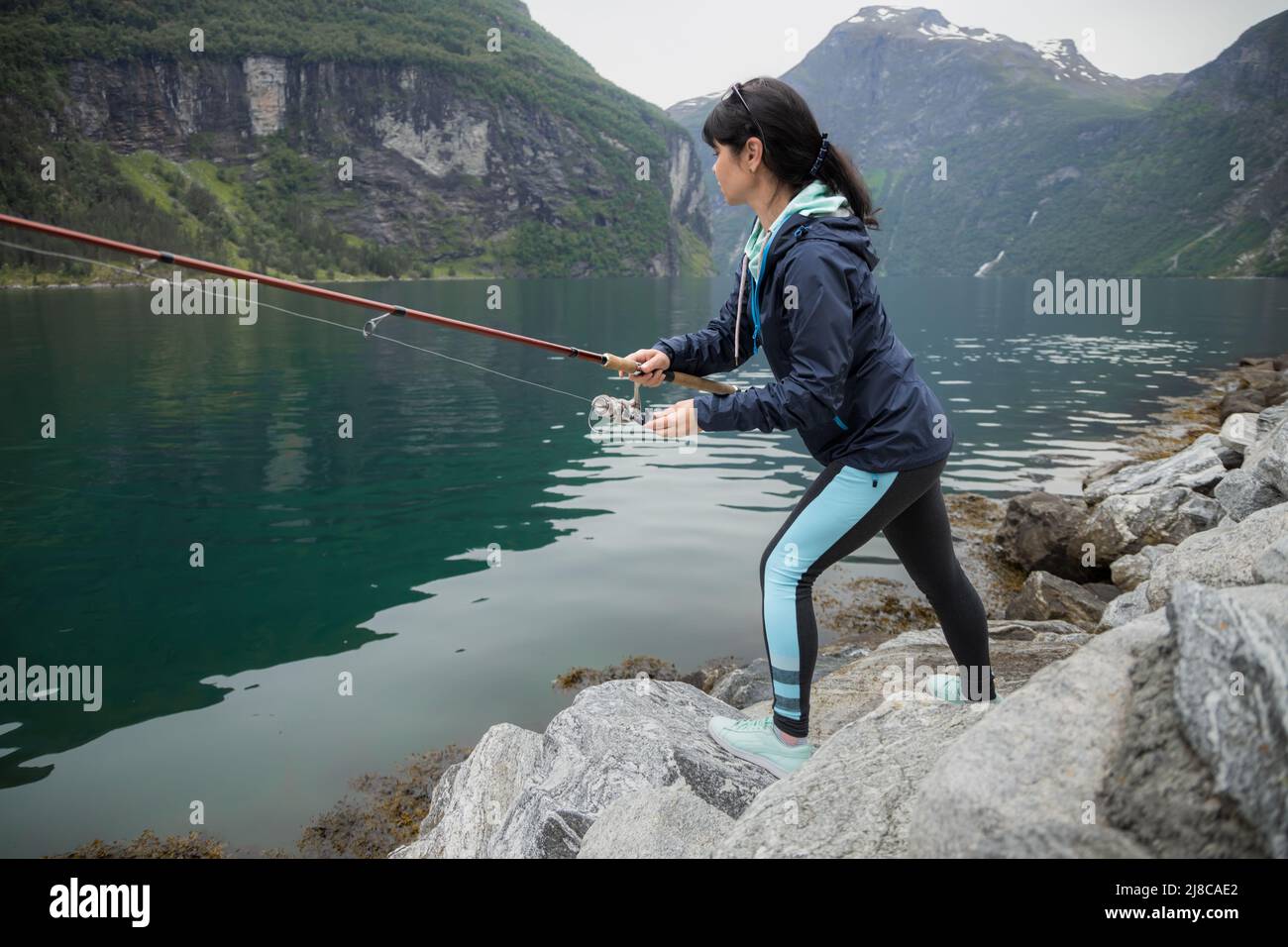 Frau fischen auf Angeln Spinning in Norwegen. Angeln in Norwegen ist eine Weise, die den lokalen Lebensstil zu Eigen zu machen. Die unzähligen Seen und Flüsse und ein umfangreiches Stockfoto