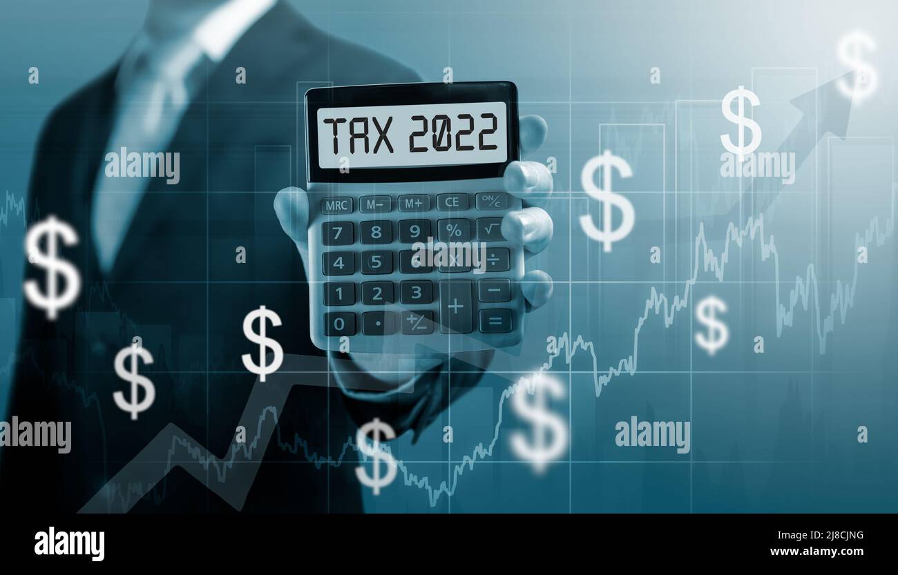 Steuer 2022 auf Rechner. Business- und Steuerkonzept .Geschäftsmann halten und zeigen Rechner mit Wort Steuer 2022. Lohn in 2023 Jahren. Zunahme der Steuerbelastung im Jahr 2 Stockfoto