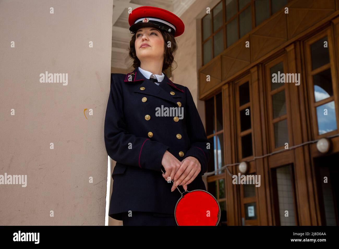 Moskau, Russland. 15.. Mai 2022. Ein Mitarbeiter der U-Bahn-Station in der Uniform von 1930-1940 Jahren steht am Eingang zur U-Bahn-Station Park Kultury in Moskau, Russland. Der Bahnhof Park Kultury feiert die Zeremonie 1935 zum Start der ersten Linie, um den 87.. Geburtstag der Moskauer Metro, Russland, zu feiern. Die Frau hält eine manuelle Scheibe, die von Mitarbeitern einer U-Bahn-Station verwendet wird, um einen Zugführer für die Abfahrt eines Zuges in der U-Bahn von Moskau zu signalisieren. Nikolay Vinokurov/Alamy Live News Stockfoto