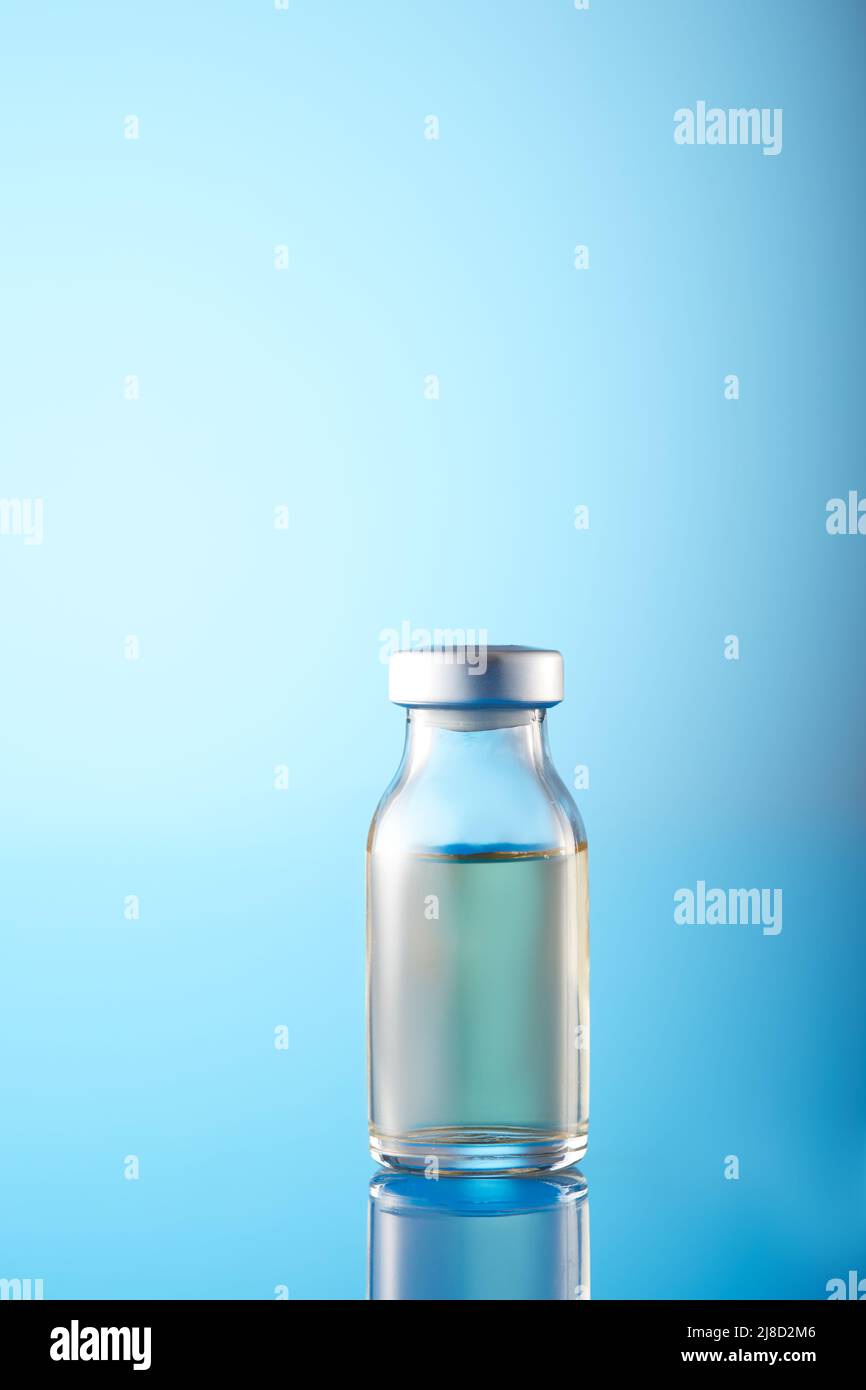 Injizierbare Impfstofffläschchen und Spritze in Blautönen aus nächster Nähe Stockfoto