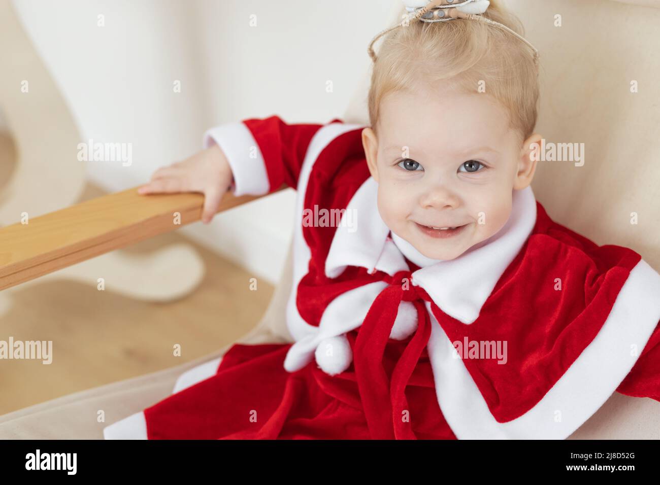 Kindermädchen in weihnachtskleid mit Cochlea-Implantaten gekleidet Spaß zu Hause - Hörgerät und innovative Technologien für die Behandlung von Taubheit Stockfoto