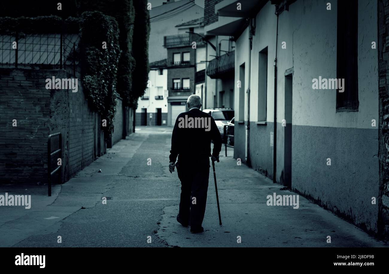 Mann, der die dunkle Straße der Stadt geht, aktives Alter, Ruhestand Stockfoto