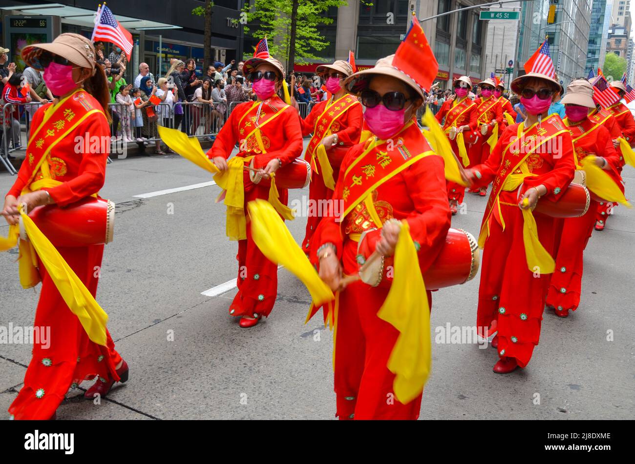 Eine Gruppe von Frauen wird bei der ersten jährlichen Kultur- und Kulturerbe-Parade der asiatisch-amerikanischen und pazifischen Inselstaaten in New York City in Rot marschieren sehen Stockfoto