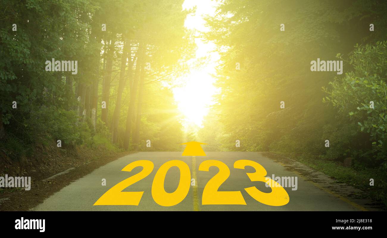 Wort 2023 geschrieben auf bewaldeten Landstraße. Konzept für das neue Jahr 2023. Jubiläumsbanner für Ziel-, Erfolg- und Motivationskonzepte Stockfoto