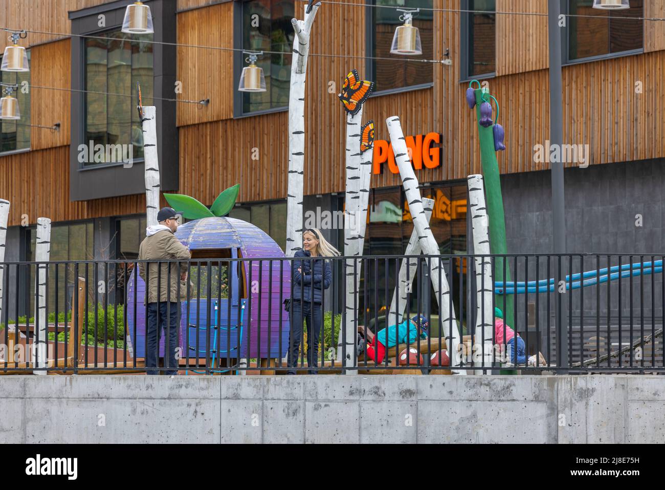 Schöner Blick auf Kinder und Erwachsene auf dem farbenfrohen Spielplatz im Freien der Stadt. Europa. Schweden. Stockfoto