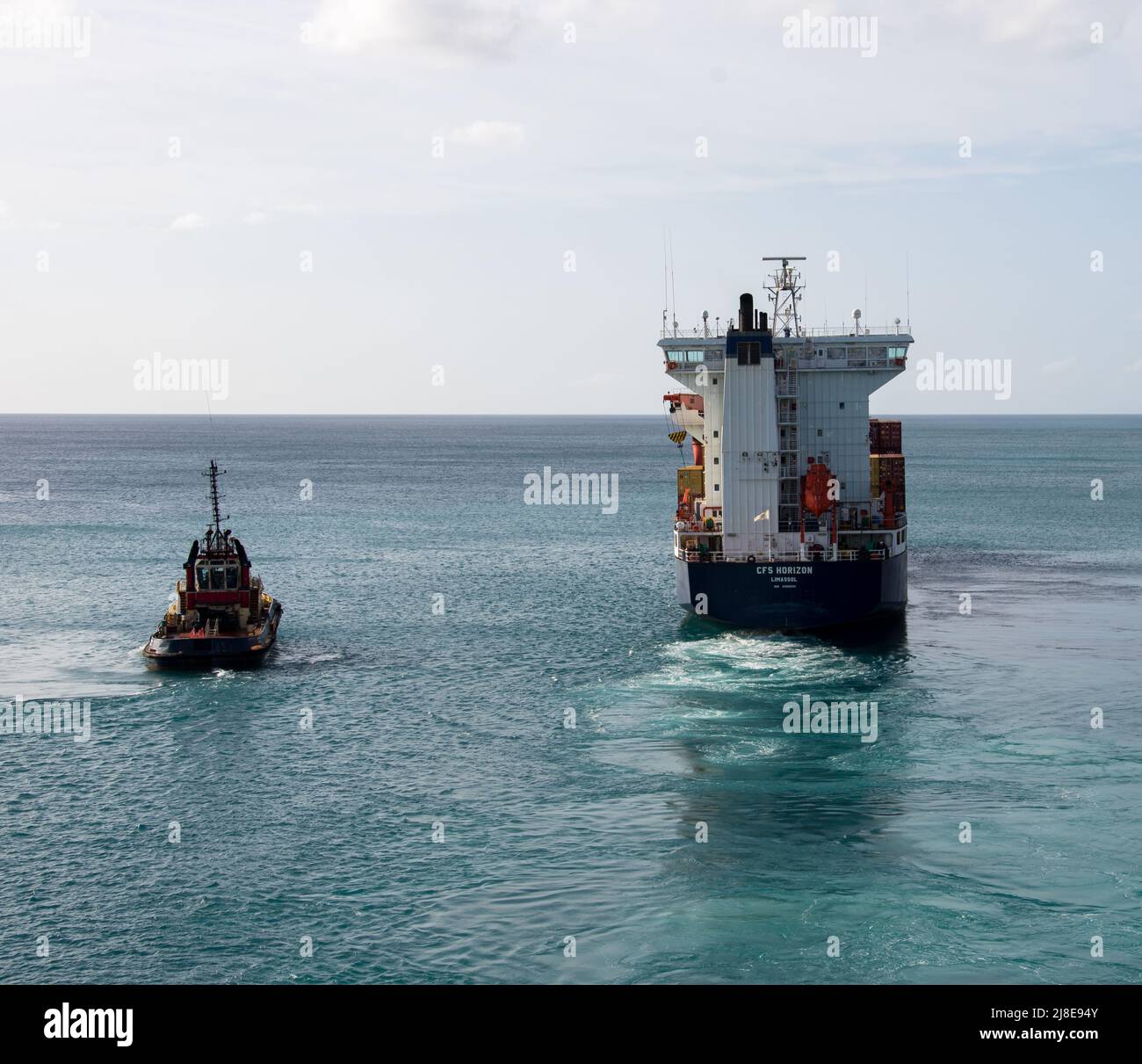 Bridgetown, Barbados - 26. März 2022: Das Frachtschiff CFS Horizon verlässt den Hafen von Bridgetown, begleitet von einem Schlepper, wie aus der Sicht Stockfoto