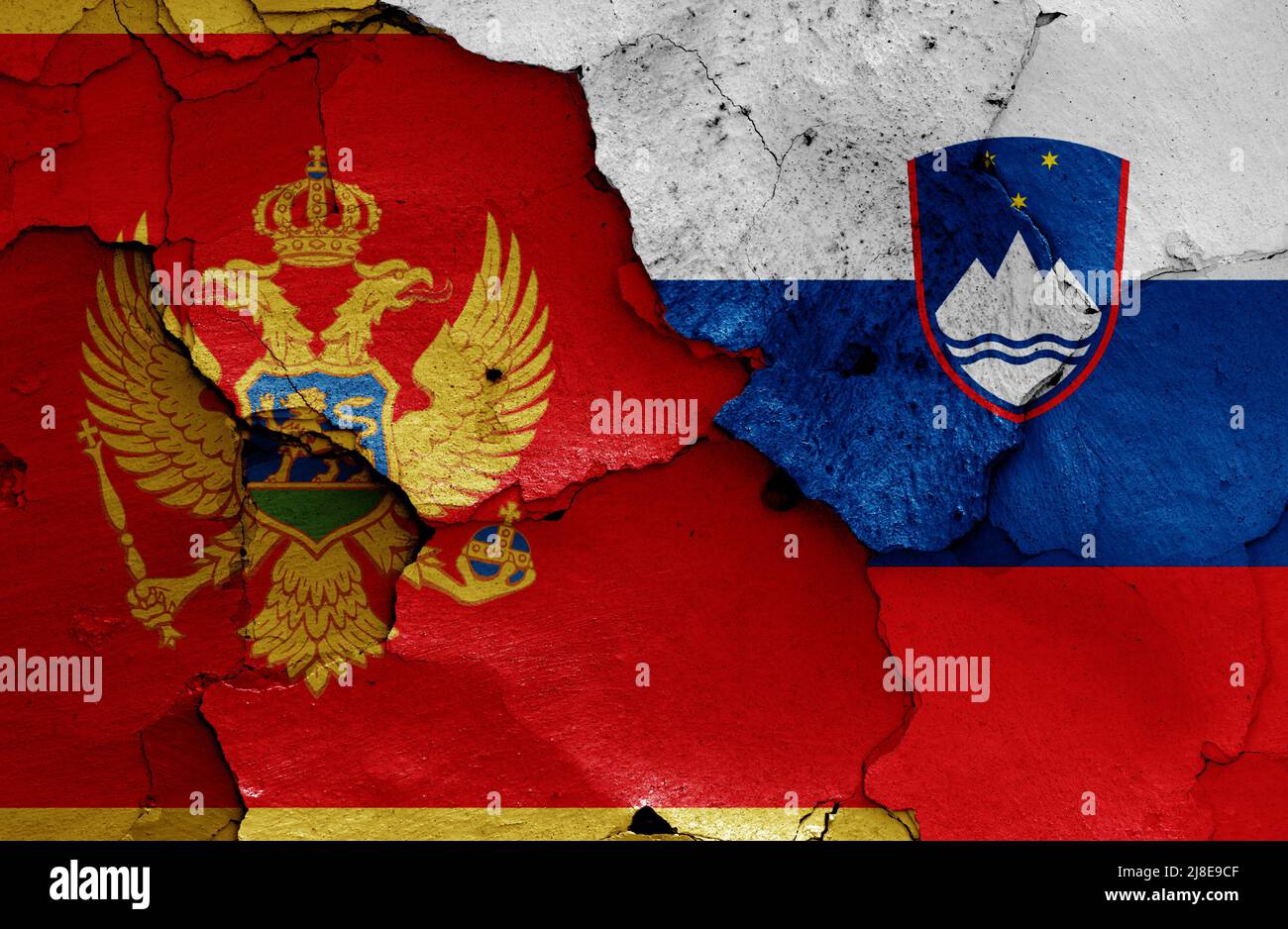 Flaggen von Montenegro und Slowenien auf rissige Wand gemalt Stockfoto