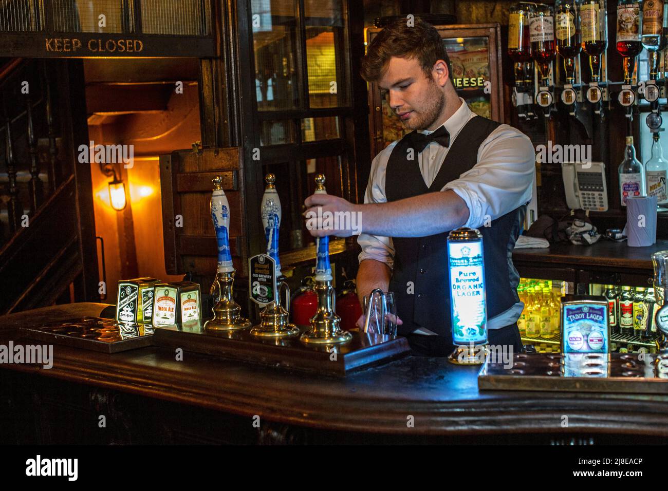 Barkeeper zieht Bier in einem traditionellen Pub, dem Ye Olde-Käse, The City of London, Großbritannien Stockfoto